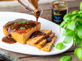 Thick, rich Beef & Rib Sauce poured over golden-brown meatloaf. Perfect for a smoky, savory dinner. Boutique Sauces gourmet BBQ sauce