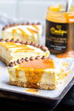 Authentic Vanilla Bean Salted Caramel Sauce drizzled over a creamy cheesecake. A rich and indulgent topping by Boutique Sauces, perfect for desserts.